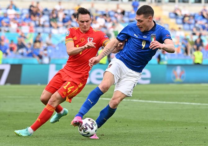 Italy's Andrea Belotti battles for possession with Wales's Connor Roberts