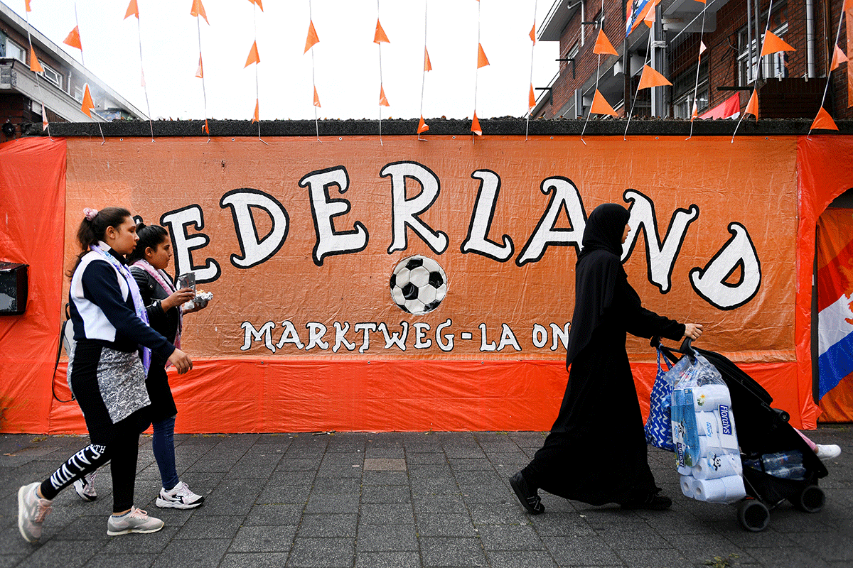  People walk at the Marktweg that is decorated in orange for the Euro 2020 football championships, in The Hague