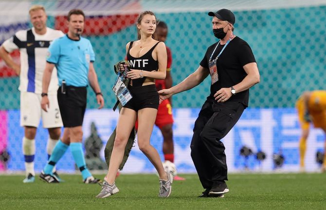A pitch invader is stopped by ground staff.