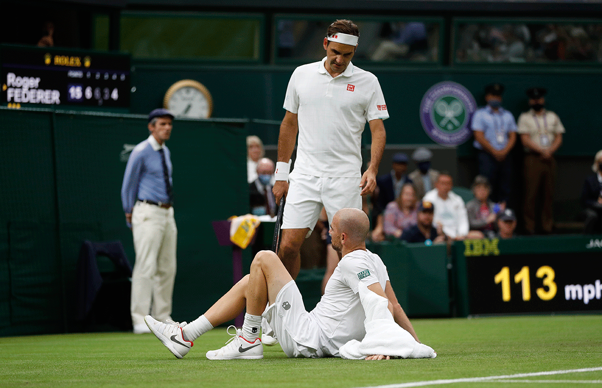 Fance's Adrian Mannarino reacts after sustaining an injury before retiring from his first round match against Switzerland's Roger Federer