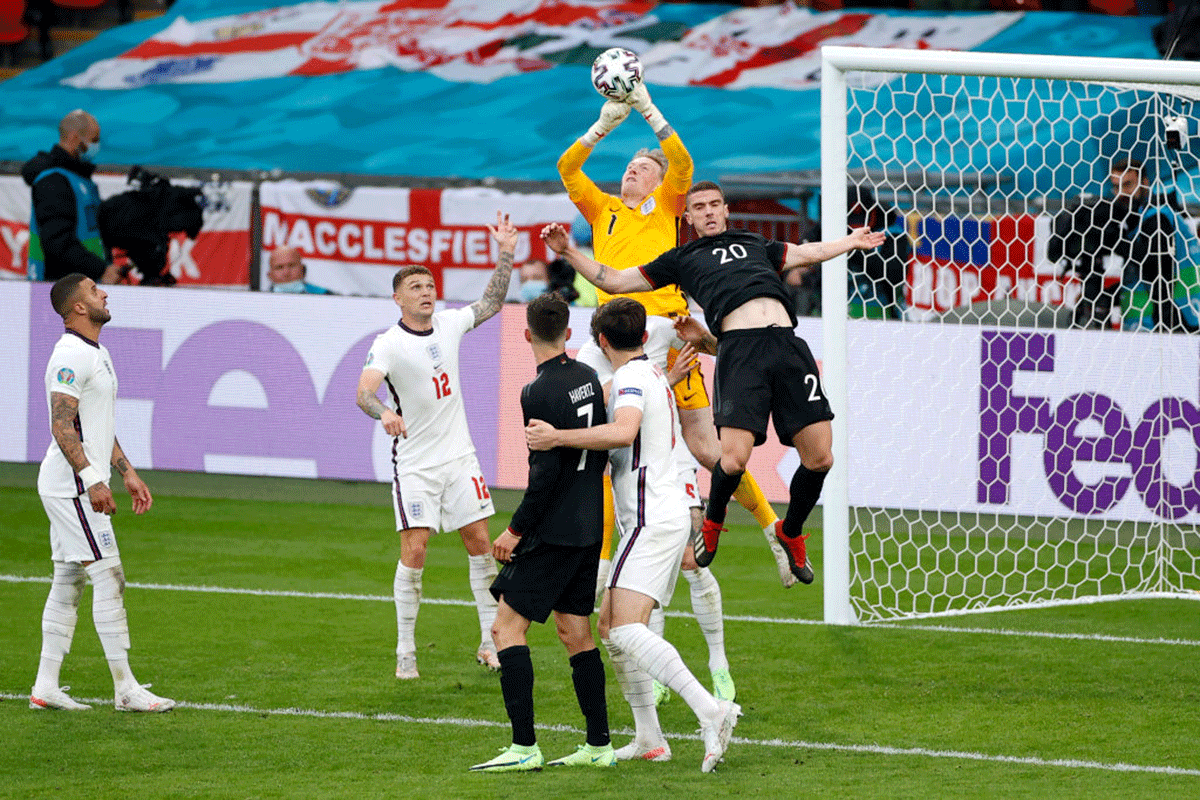 England 'keeper Jordan Pickford punches the ball whilst under pressure from Germany's Robin Gosens