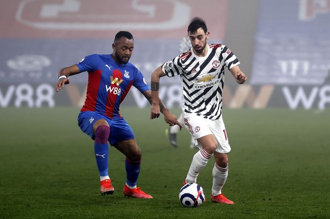 Manchester United's Bruno Fernandes battles for possession with Crystal Palace's Jordan Ayew.