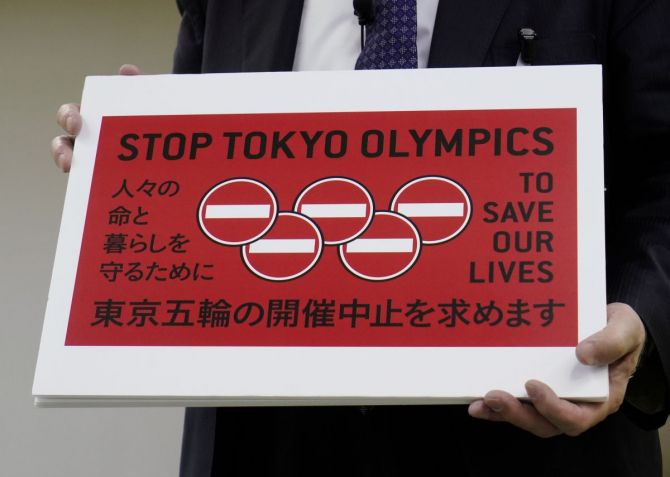Lawyer Kenji Utsunomiya shows off a placard during a news conference after he and anti-Olympics petition organizer to submit a petition calling for the Tokyo 2020 Olympics to be cancelled to Tokyo Governor Yuriko Koike (not in picture) at the Tokyo Metropolitan Office press club in Tokyo, Japan, on Friday