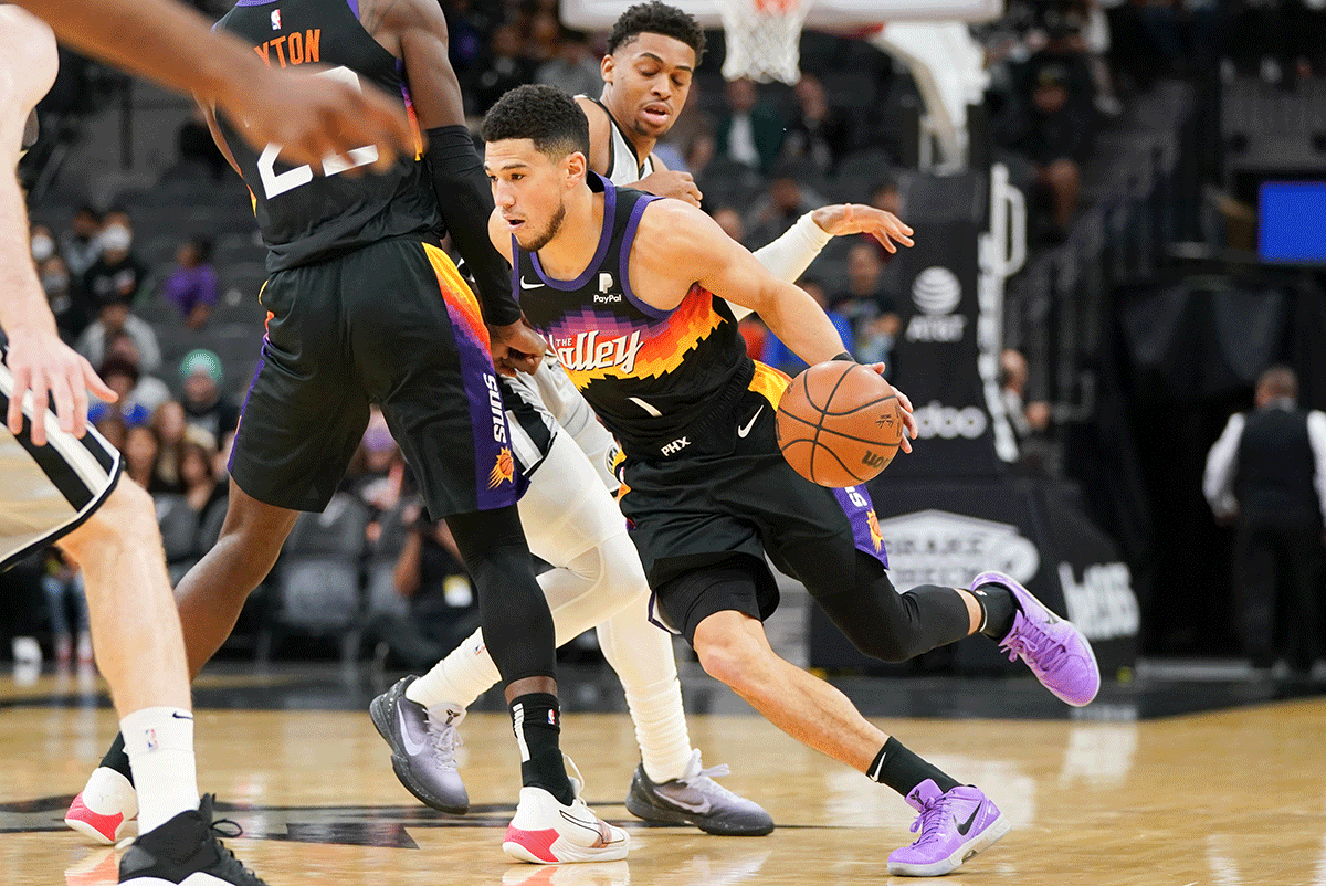 Phoenix Suns guard Devin Booker (1) dribbles the ball in the first half during the match against the San Antonio Spurs at the AT&T Center in San Antonio, Texas on Monday