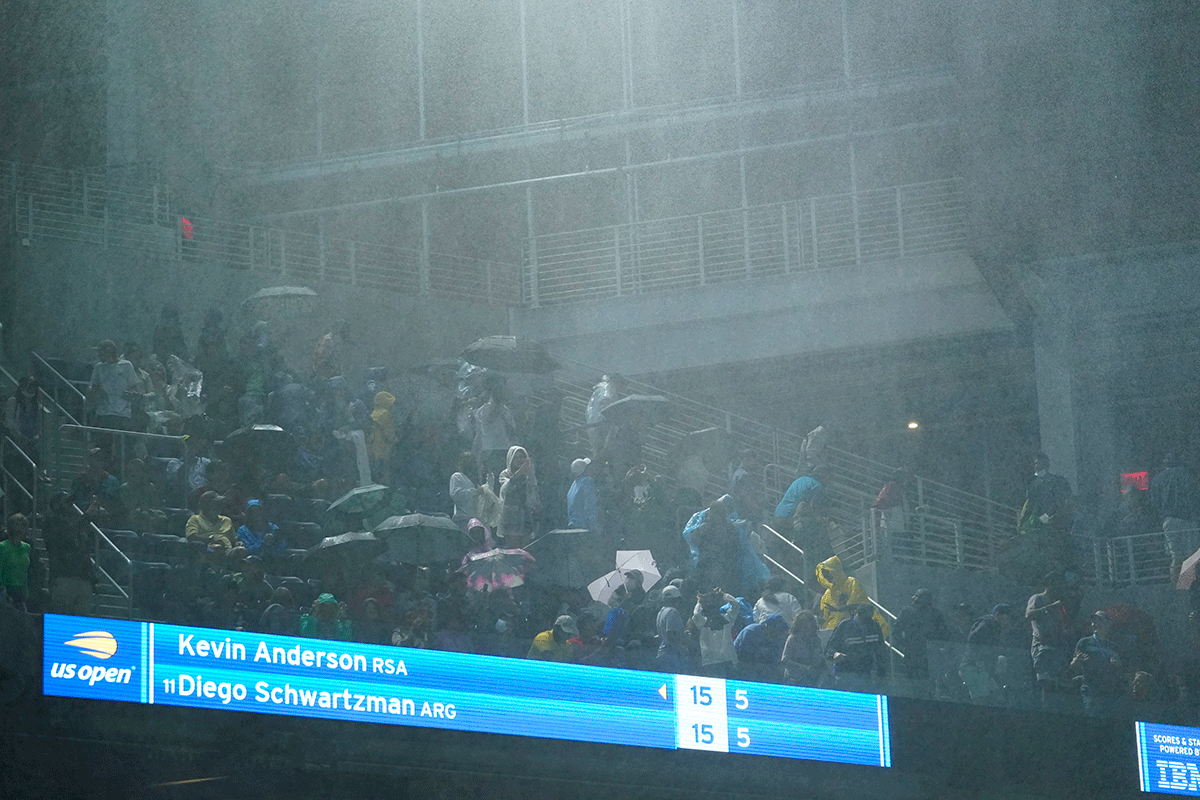 Rain falls into Louis Armstrong Stadium from the openings during the match between Diego Schwartzman and Kevin Anderson
