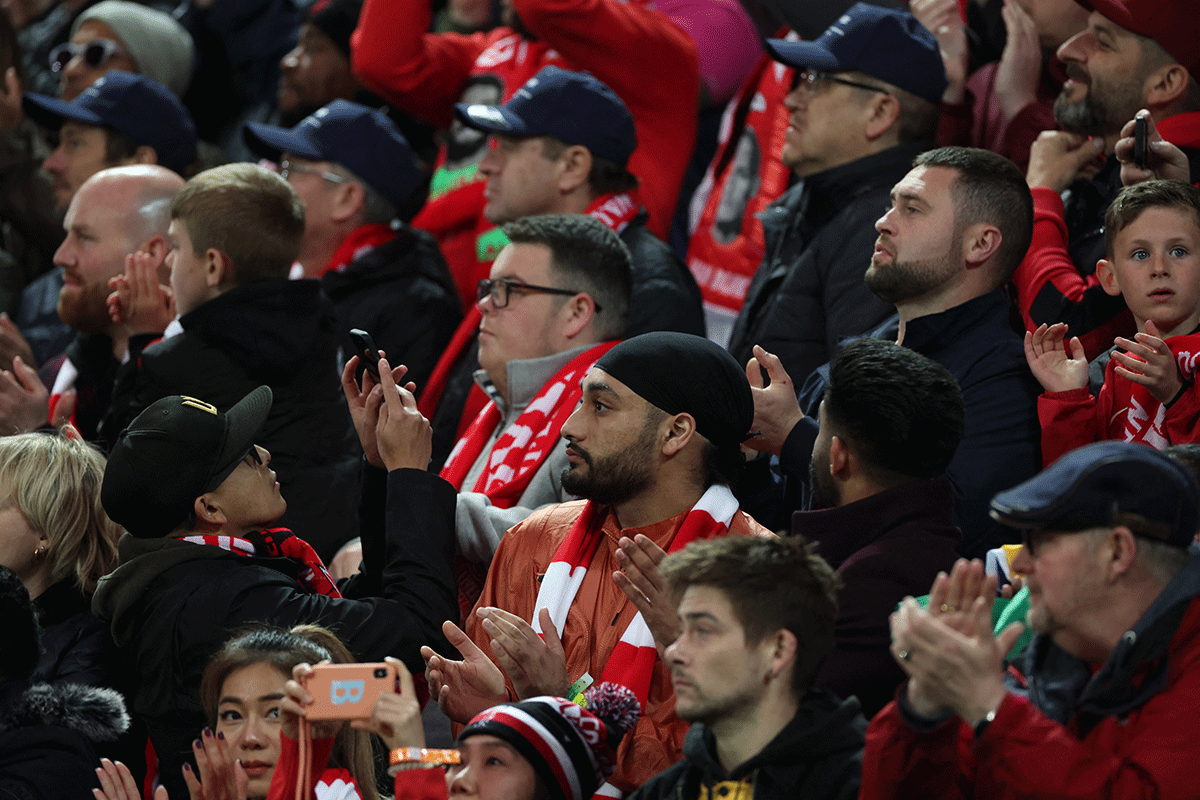 Liverpool fans applaud on the seventh minute for Manchester United 's Cristiano Ronaldo and his family during their EPL game at Anfield on Tuesday