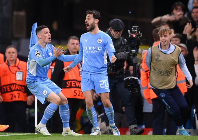 Bernardo Silva celebrates with teammate Phil Foden after scoring Manchester City's fourth goal.