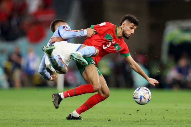 Morocco's Noussair Mazraoui battles for possession with Spain's Ferran Torres