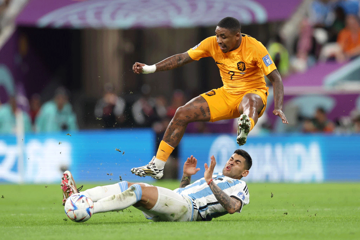 The Netherlands' Steven Bergwijn is tackled by Argentina's Cristian Romero. Romero was penalised for the challenge 