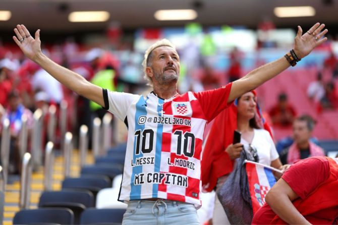 A fan wearing a half-and-half shirt with the names of Lionel Messi of Argentina and Luka Modric of Croatia