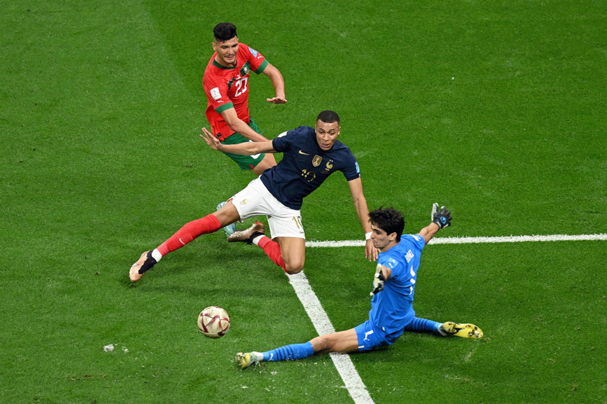 France's Kylian Mbappe is challenged by Morocco's Yassine Bounou and Achraf Dari