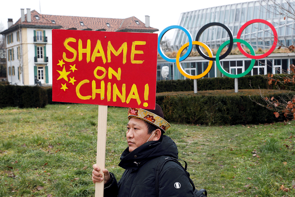A member of Tibetan community living in Europe holds a placard during a protest in front of the headquarters of the International Olympic Committee (IOC) in Lausanne, Switzerland