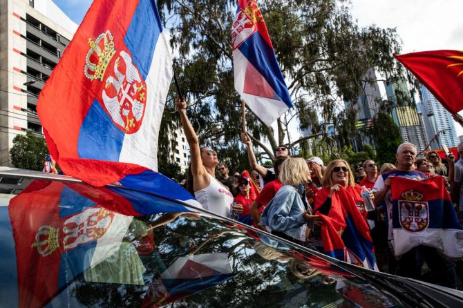 Serbian tennis fans and anti-vaccination protesters rally outside the Park Hotel in Melbourne on Saturday