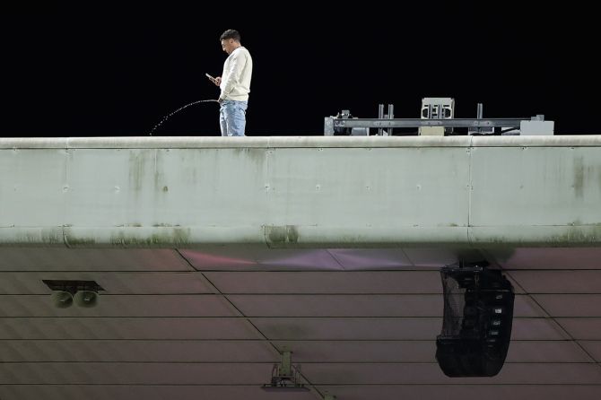 A spectator is seen on the roof of a grandstand during game three of the International Test series between the Australia Wallabies and England at the Sydney Cricket Ground on July 16, 2022.