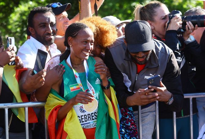 Ethiopia's Gotytom Gebreslase celebrates with spectators after winning the women's marathon.