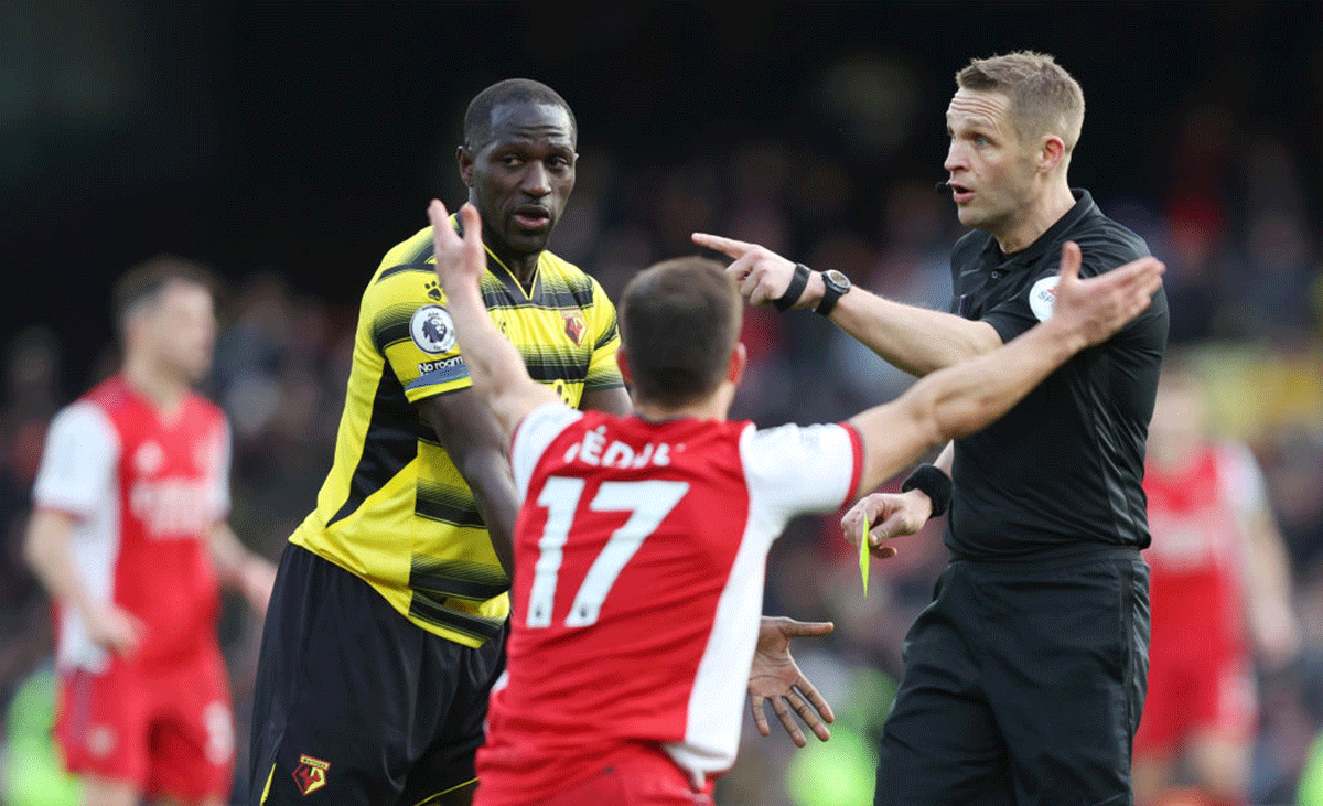 Arsenal's Cedric Soares reacts before receiving a yellow card from referee Craig Pawson