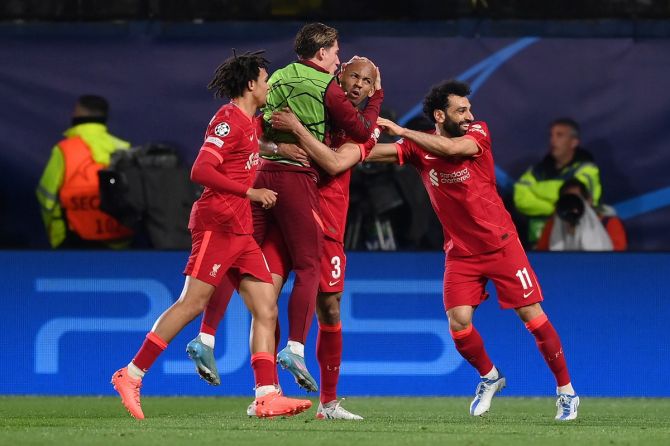 Fabinho celebrates with teammates Kostas Tsimikas, Mohamed Salah and Trent Alexander-Arnold after scoring Liverpool's first goal.