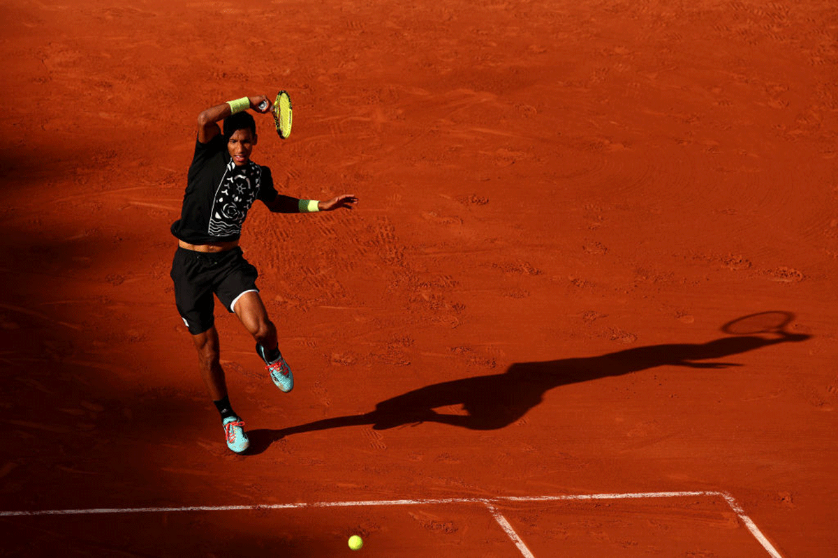 Felix Auger-Aliassime plays a forehand return against Rafael Nadal