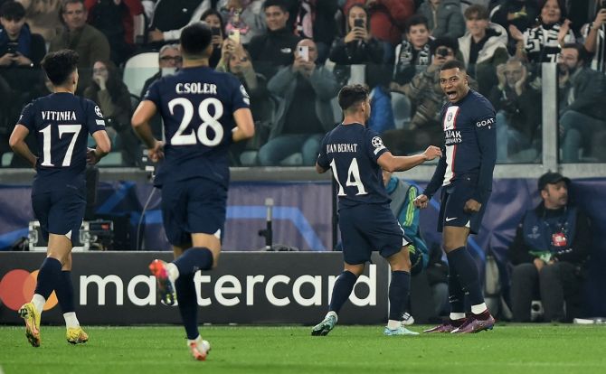 Kylian Mbappe celebrates scoring Paris St Germain's first goal with Juan Bernat during the Champions League Group H match against Juventus, at Allianz Stadium, Turin, Italy.
