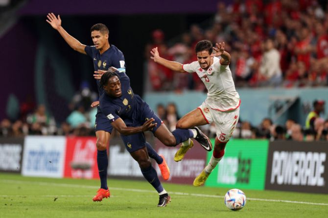 Tunisia's Mohamed Ben Romdhane is challenged by Axel Disasi and Raphael Varane of France