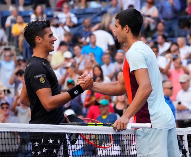 Carlos Alcaraz and Federico Coria meet at the net after their second round match.