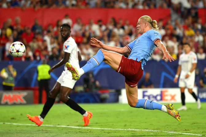 Erling Haaland stretches to reach a cross from Kevin De Bruyne and score Manchester City's first goal.