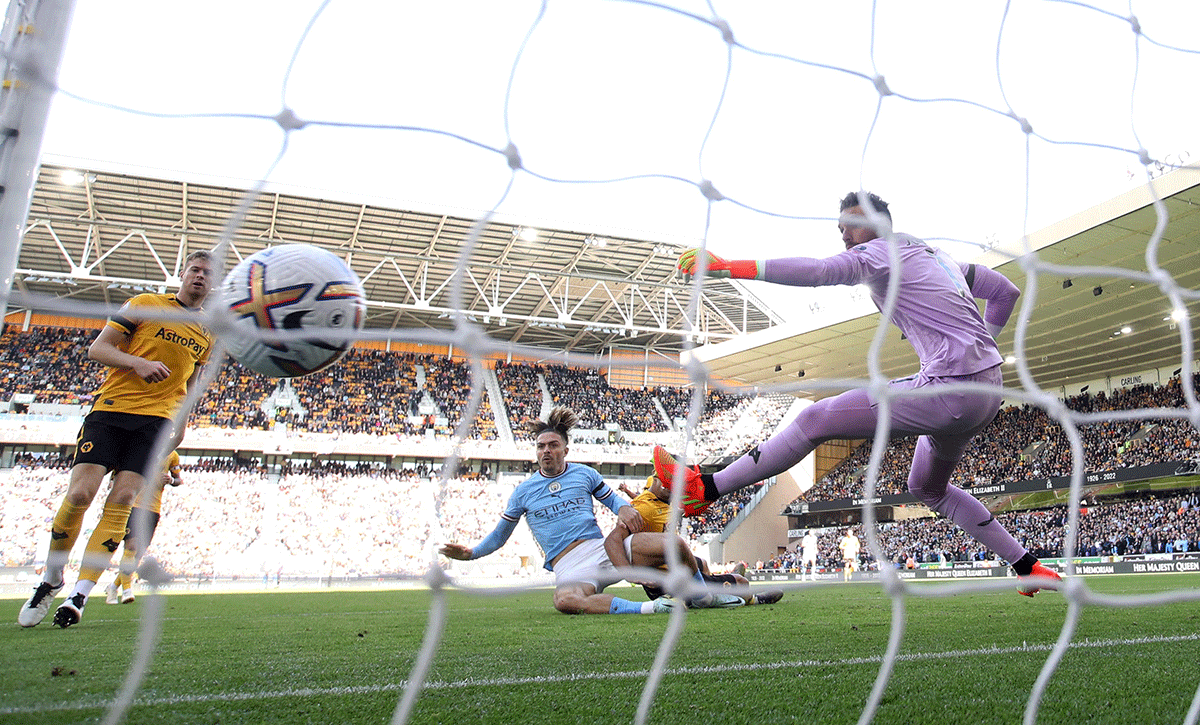 Manchester City's Jack Grealish scores their first goal past Wolverhampton Wanderers' Jose Sa during their match at Molineux Stadium, Wolverhampton 