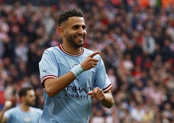 Riyad Mahrez exults after scoring Manchester City's third goal and completing his hat-trick. 