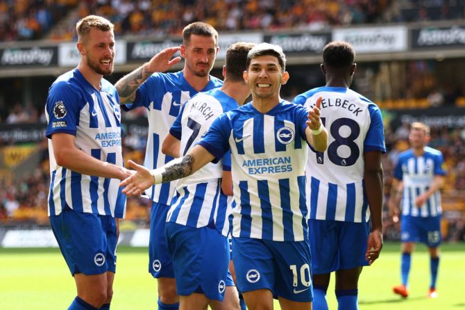 Brighton & Hove Albion's Solly March celebrates with Julio Enciso and teammates after scoring their third goal against Wolverhampton Wanderers at Molineux Stadium, Wolverhampton