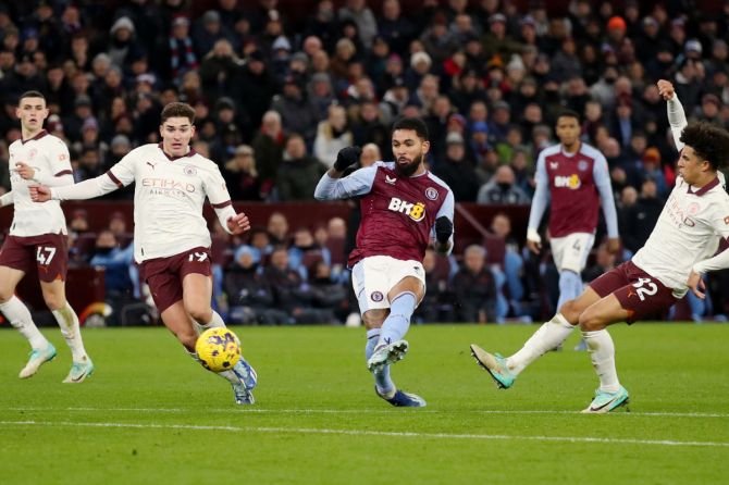 Aston Villa's Douglas Luiz in action with Manchester City's Julian Alvarez and Rico Lewis 