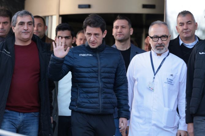 Turkish referee Halil Umut Meler, accompanied by head doctor Mehmet Yorubulut, greets media members as he leaves from a hospital in Ankara, Turkey December 13, 2023