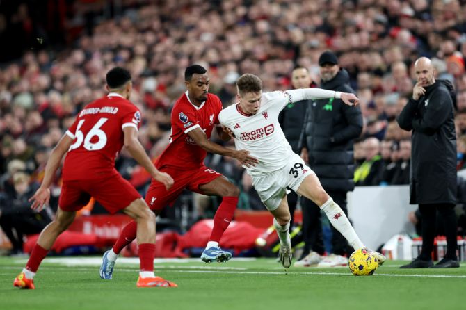 Manchester United's Scott McTominay is challenged by Liverpool players during their English Premier League match at Anfield in Liverpool on Sunday