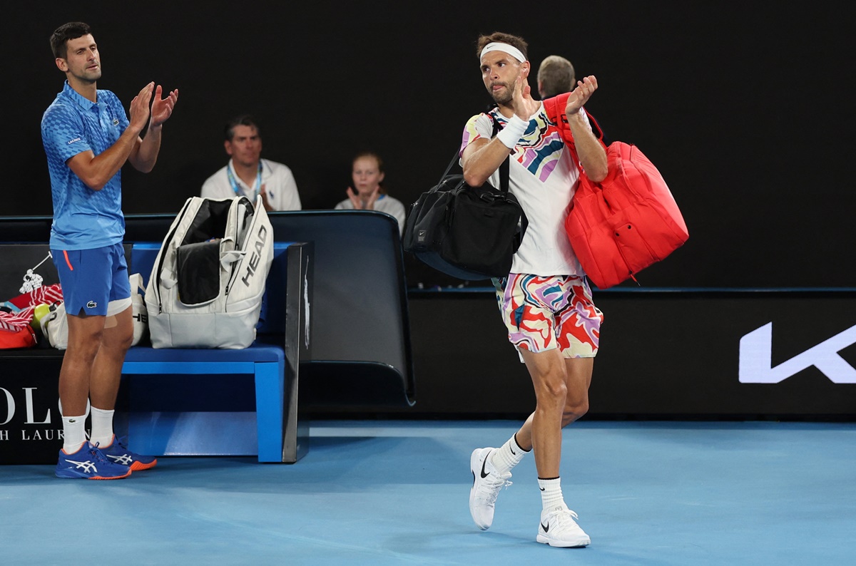 Novak Djokovic applauds as Grigor Dimitrov walks off the court.