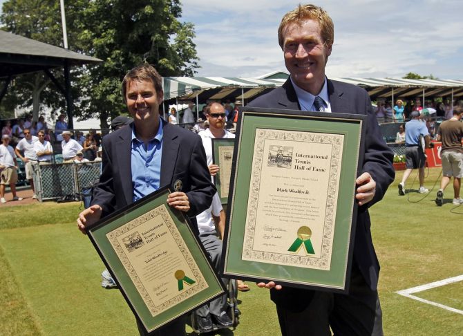 Doubles partners Mark Woodforde, right, and Todd Woodbridge show off their plaques around center court after being inducted into the International Tennis Hall of Fame in Newport, Rhode Island July 10, 2010. 