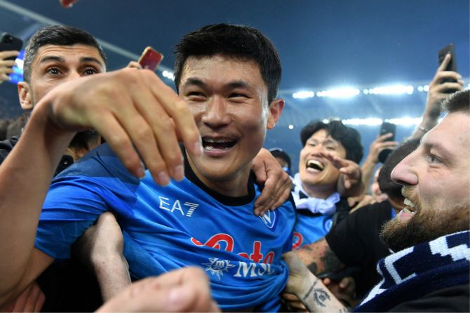Napoli's Kim Min-jae celebrates with fans on the pitch after winning Serie A on Thursday 