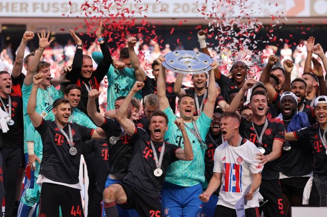 Manuel Neuer celebrates with the trophy and teammates after Bayern Munich beat FC Cologne to win the Bundesliga, at RheinEnergieStadion, Cologne, Germany, on Saturday.