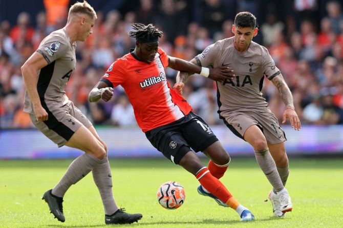 Luton Town's Elijah Adebayo is challenged by Tottenham Hotspur's Cristian Romero and Micky van de Ven