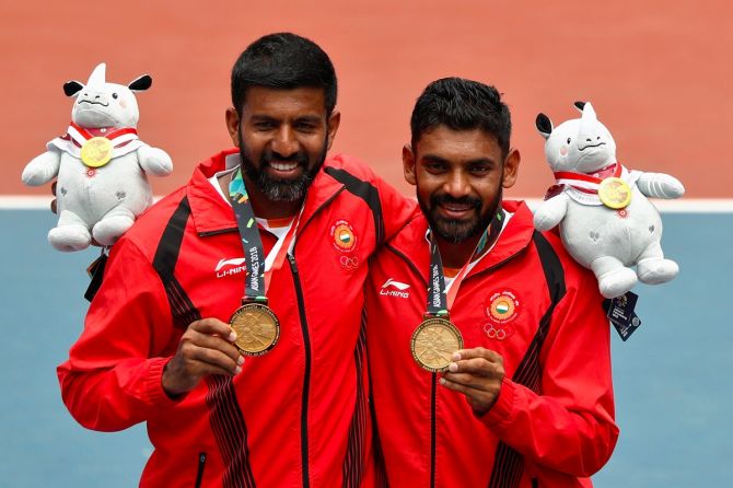 Rohan Bopanna and Divij Sharan celebrate with their medals and plush mascots after winning the men's doubles gold at the 2018 Asian Games in Palembang, Indonesia, August 24, 2018.