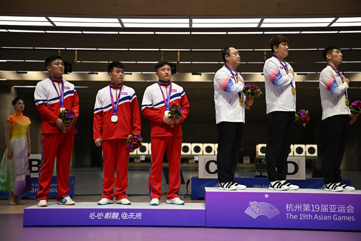 North Korea's Kwon Kwang-il, Pak Myong-won and Songjun Yu decline to turn towards the flag during the rendition of the national anthem of South Korea, gold medallists in Men's Team 10m Running Target Mixed event. Ha Kwang-chul, Jeong You-jin and Your Bin Kwak comprised winners South Korea.