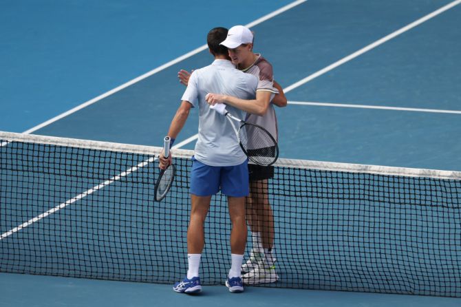 Jannik Sinner and Novak Djokovic embrace at the net after the match