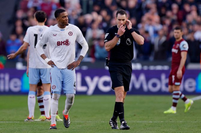 Referee Jarred Gillett walks to the VAR monitor to review a West Ham United goal that is later disallowed