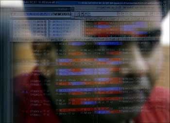 A broker looks at a terminal while trading at a stock brokerage firm in Mumbai.
