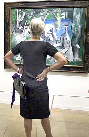 A visitors looks at a painting by Spanish artist Pablo Ruiz Picasso
