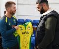 Warner presents signed team shirt to injured net bowler