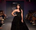 Black magic! Rhea casts a spell in layered gown