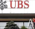 UBS to repay Swiss bailout loan, cautious on Q3