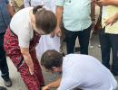 Rahul ties mother's shoelaces as she walks besides him