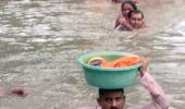 Cop carries baby in tub on his head in neck-deep water