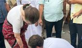 Rahul ties mother's shoelaces as she walks besides him