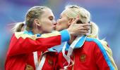 Russia's golden girls protest anti-gay law with podium kiss